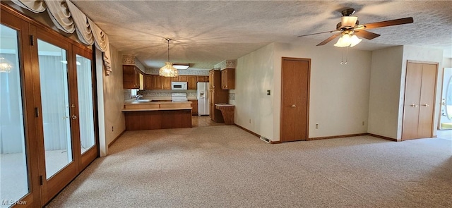 interior space featuring light colored carpet, a textured ceiling, and ceiling fan
