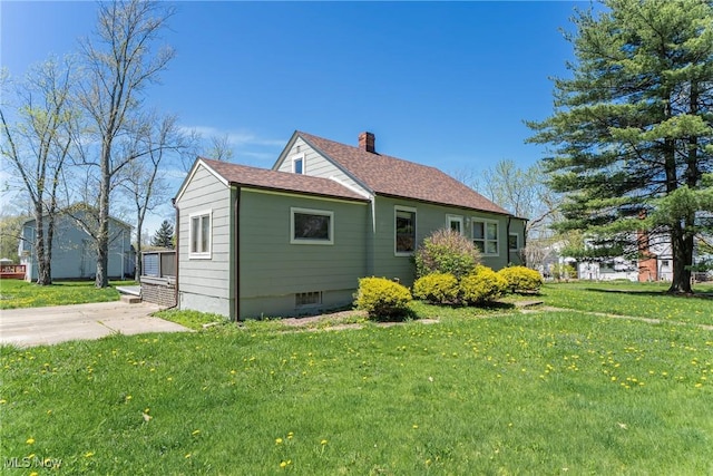 view of property exterior featuring a yard, a chimney, and a shingled roof