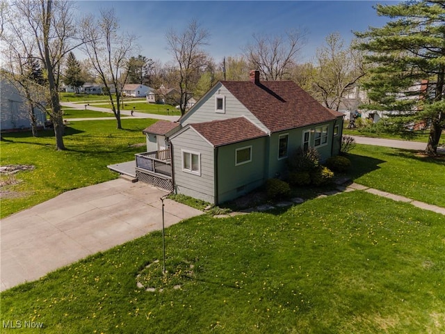 view of home's exterior featuring a lawn, a chimney, and a shingled roof