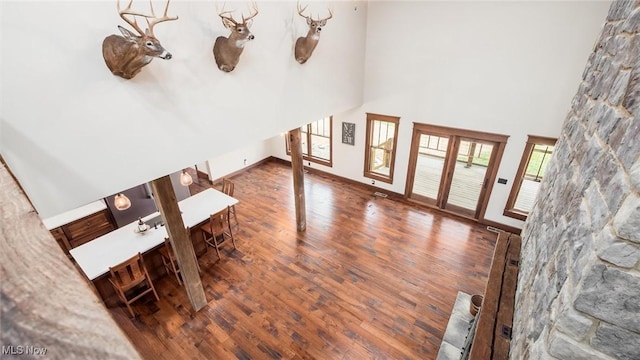 foyer featuring baseboards, a high ceiling, and wood finished floors