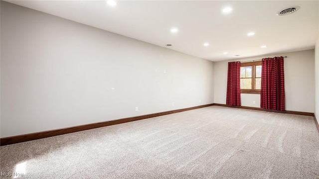spare room with recessed lighting, baseboards, visible vents, and light carpet