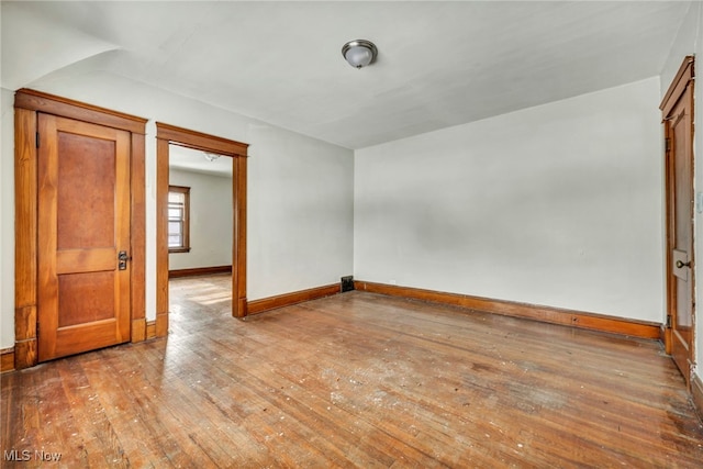 empty room featuring wood-type flooring and baseboards