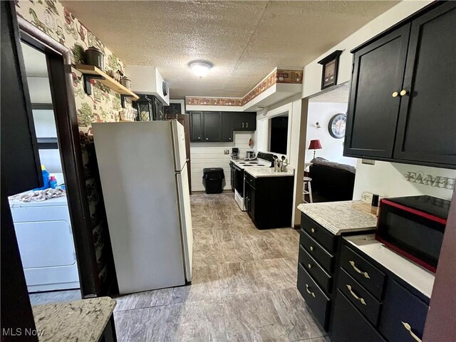 621 Grant St Rear, Rear, Mcmechen, WV 26040 - kitchen featuring washer / dryer, white appliances, light countertops, a textured ceiling, and dark cabinets