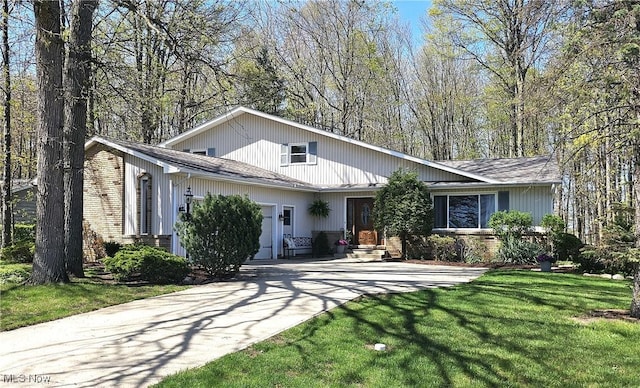 view of front facade featuring brick siding, a front lawn, and driveway