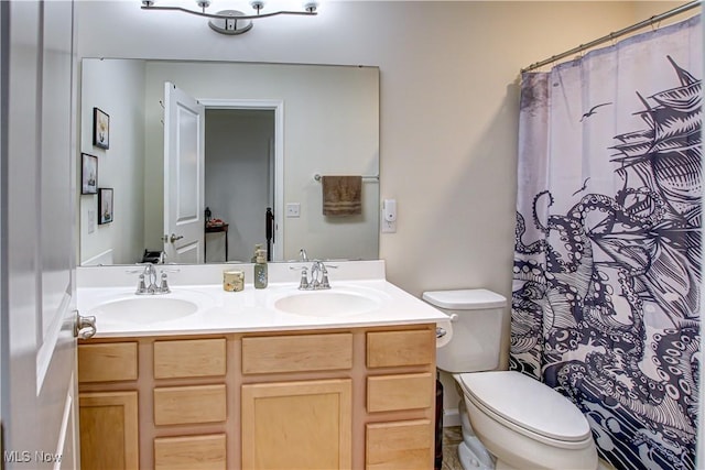 bathroom with double vanity, toilet, and a sink