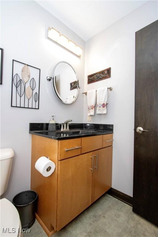 bathroom with vanity, baseboards, tile patterned floors, and toilet