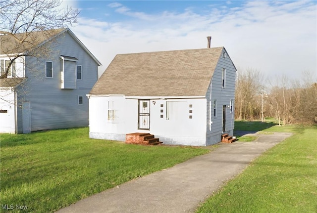 view of front of property featuring a shingled roof and a front yard