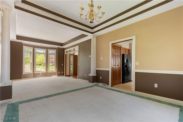 spare room featuring carpet floors, ornamental molding, visible vents, ornate columns, and a chandelier