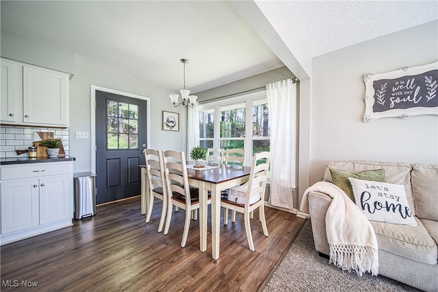 dining area featuring an inviting chandelier and dark wood-style floors