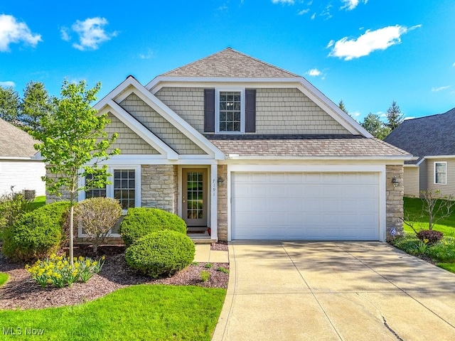 view of front of property with roof with shingles, an attached garage, driveway, and stone siding