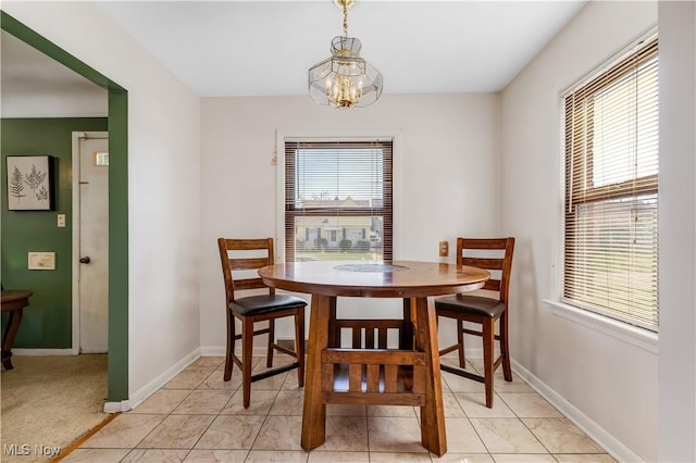 dining space featuring an inviting chandelier and baseboards