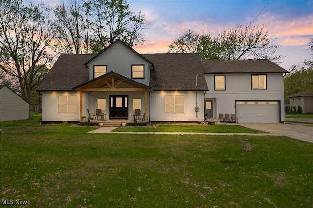 modern inspired farmhouse with driveway, a shingled roof, a front yard, and a garage