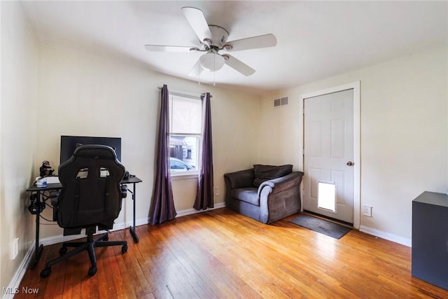 office with baseboards, ceiling fan, visible vents, and light wood-style flooring