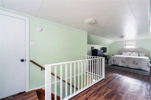 bedroom featuring wood finished floors and lofted ceiling