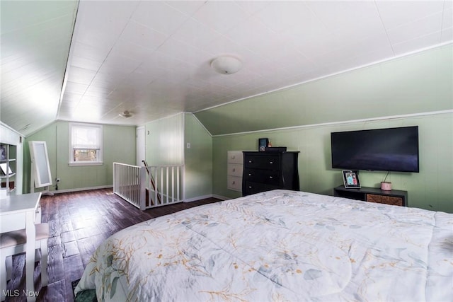 bedroom featuring baseboards, lofted ceiling, and wood finished floors