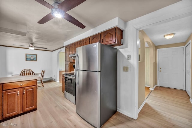 kitchen with ceiling fan, appliances with stainless steel finishes, arched walkways, baseboards, and under cabinet range hood