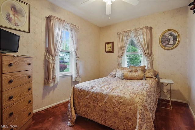 bedroom with baseboards, multiple windows, and wallpapered walls
