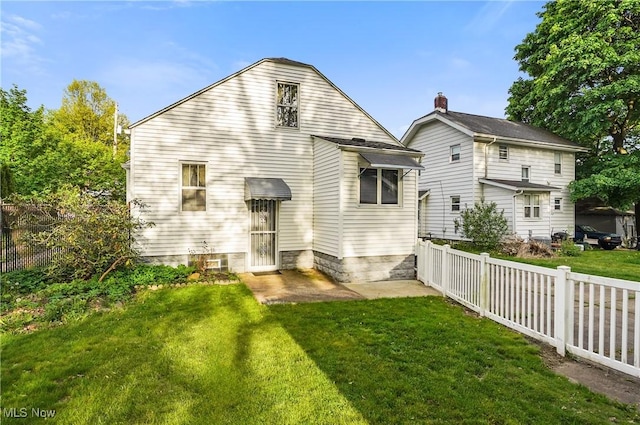 back of house featuring a lawn and fence