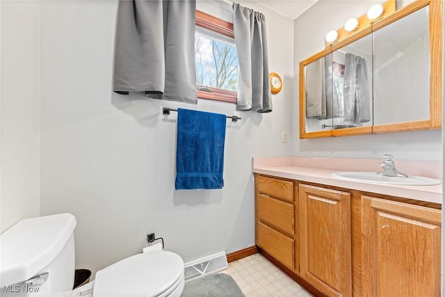 bathroom featuring visible vents, tile patterned floors, baseboards, vanity, and toilet