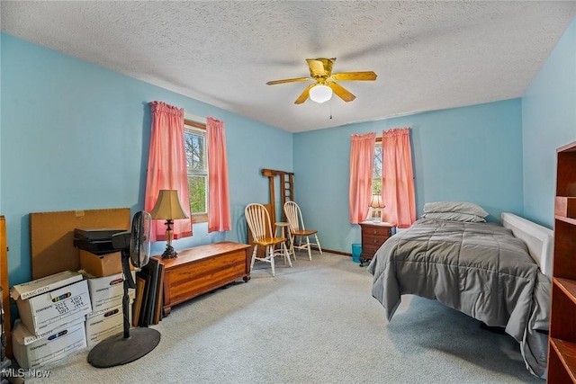 bedroom with a ceiling fan, carpet flooring, and a textured ceiling