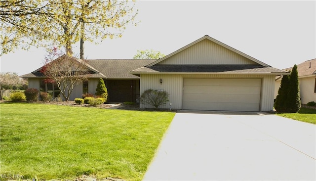 ranch-style home with roof with shingles, an attached garage, concrete driveway, and a front lawn