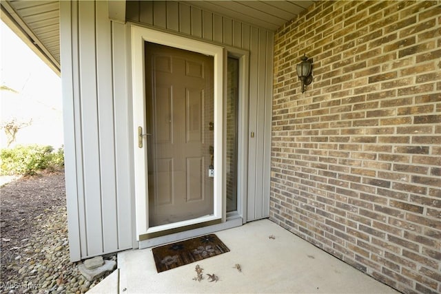 doorway to property with brick siding and board and batten siding