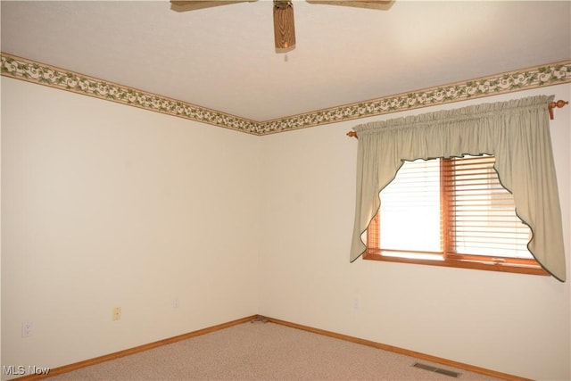 unfurnished room with a ceiling fan, baseboards, light colored carpet, and visible vents