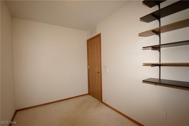 unfurnished room with visible vents, baseboards, and light carpet
