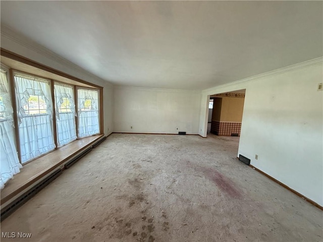 empty room featuring baseboards and ornamental molding