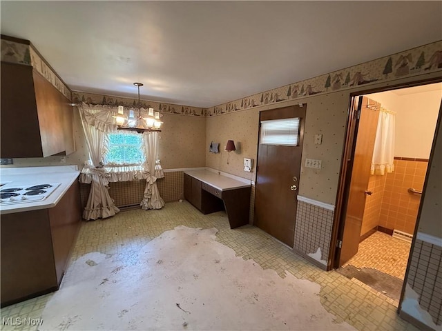 interior space with a wainscoted wall, wallpapered walls, and a chandelier