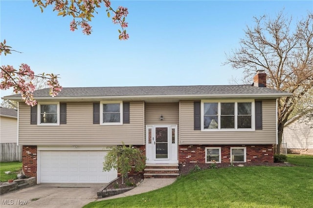 bi-level home with an attached garage, a front lawn, brick siding, a chimney, and driveway