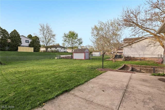view of yard with a fenced backyard, a patio, an outdoor structure, and a shed