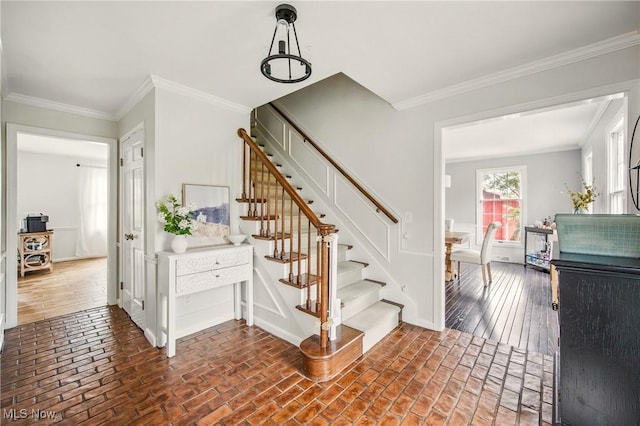 staircase with crown molding, baseboards, and brick floor