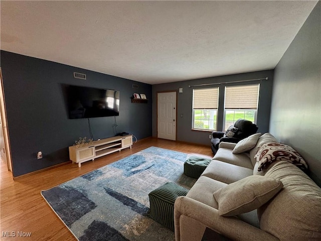 living area with wood finished floors and visible vents
