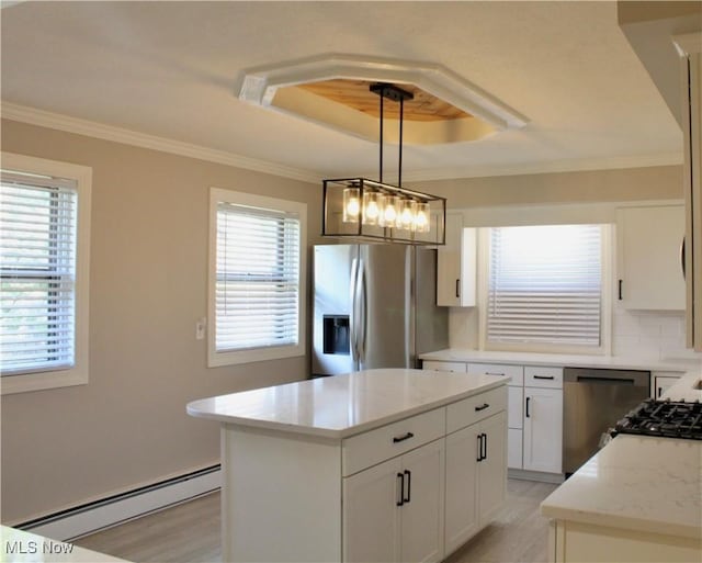 kitchen with a baseboard radiator, light wood-style flooring, a tray ceiling, and stainless steel appliances