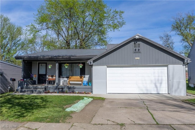 ranch-style house with covered porch, a front yard, metal roof, an attached garage, and driveway