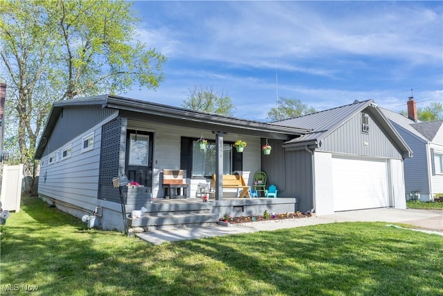 3050 Latimer Ave, Ashtabula, OH 44004 - view of front of house featuring covered porch, a garage, a front lawn, and concrete driveway