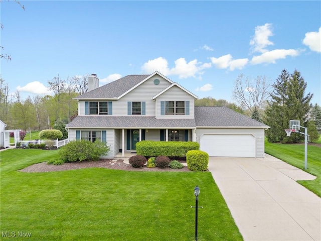 traditional-style home with a garage, a chimney, driveway, and a front yard