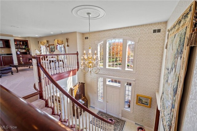 entrance foyer with an inviting chandelier, baseboards, and visible vents