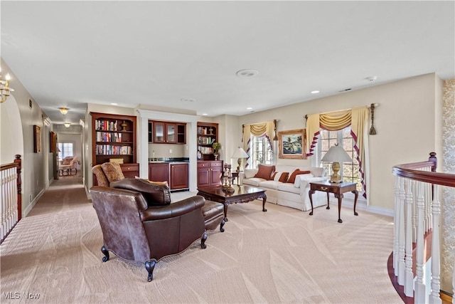 living area with light colored carpet, recessed lighting, baseboards, and plenty of natural light