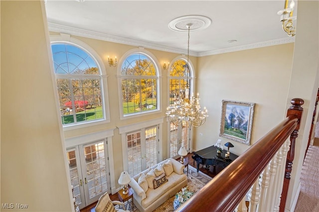 interior space with crown molding, a high ceiling, a notable chandelier, and french doors
