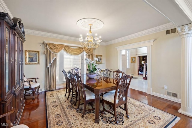 dining area featuring a notable chandelier, ornamental molding, wood finished floors, and visible vents