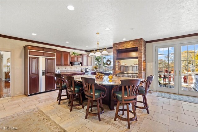 dining area with a textured ceiling, french doors, stone tile floors, recessed lighting, and ornamental molding