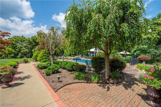 view of property's community featuring a swimming pool and fence