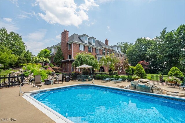 view of swimming pool with fence, a fenced in pool, and a patio area