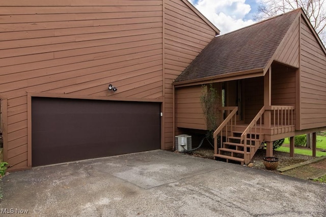 view of front of house featuring roof with shingles, a garage, and aphalt driveway