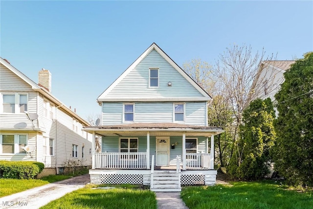 view of front of property featuring covered porch and a front lawn