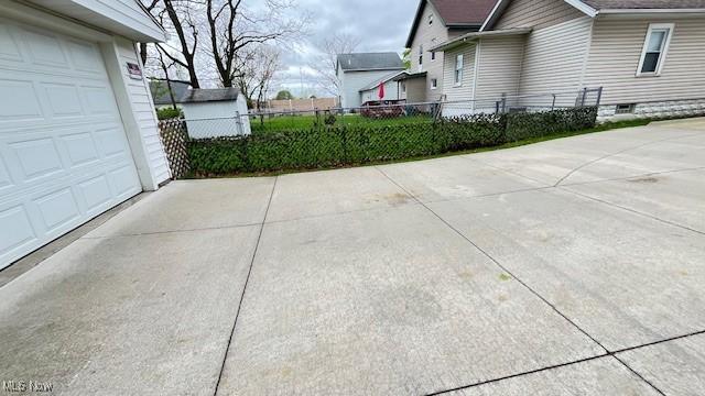 view of home's exterior with fence and concrete driveway