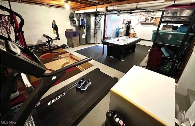 recreation room featuring concrete block wall, heating unit, and independent washer and dryer