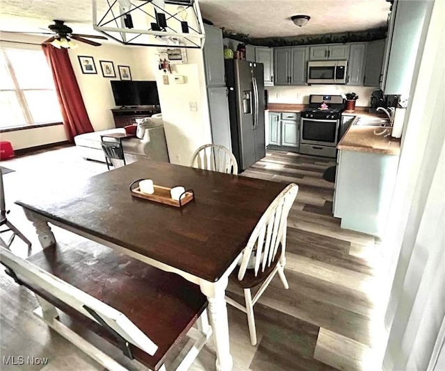 dining room with a ceiling fan and dark wood finished floors